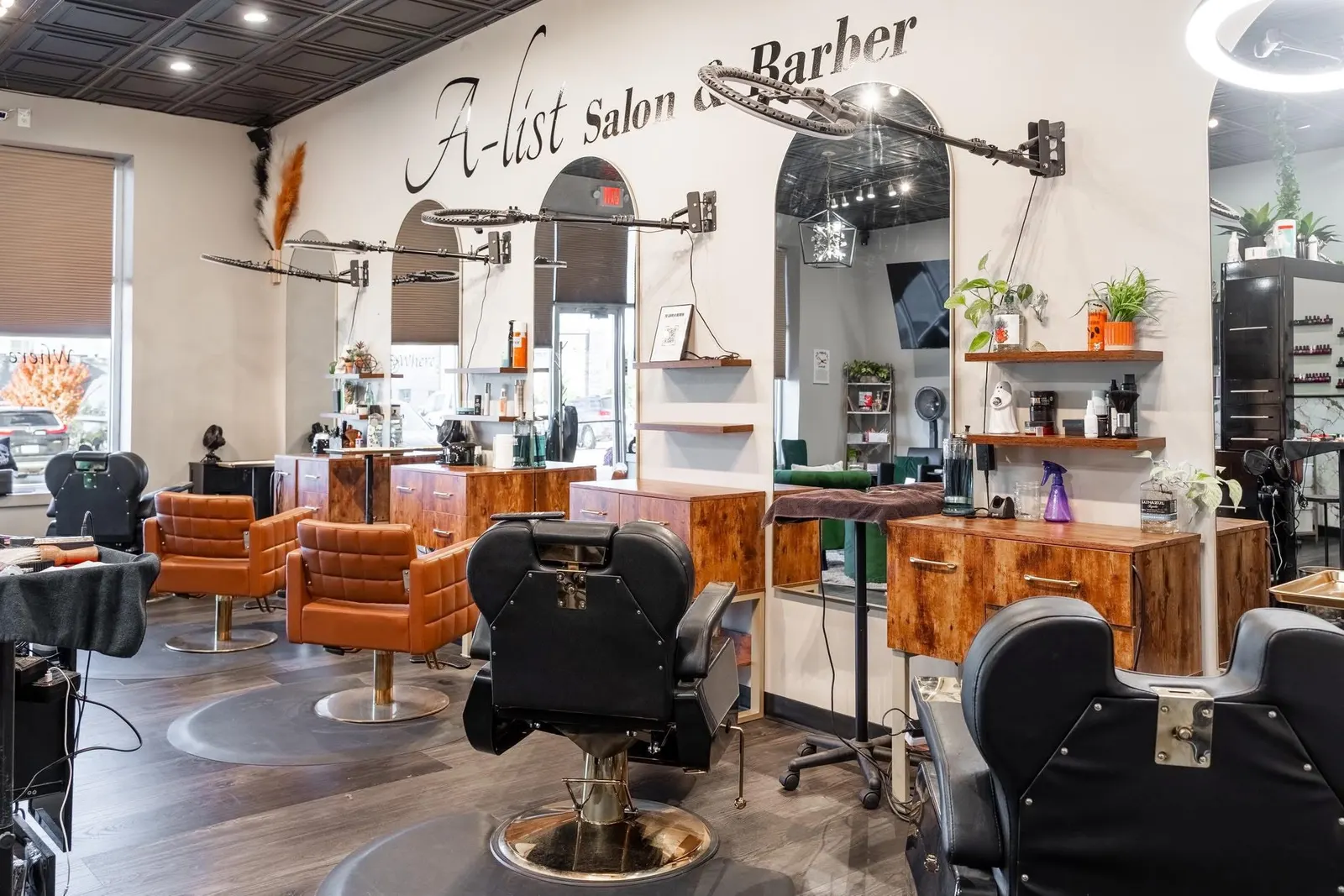 Inside A-List Salon & Barber: cognac leather salon chairs and black barber chairs beneath the A-List script on the wall
